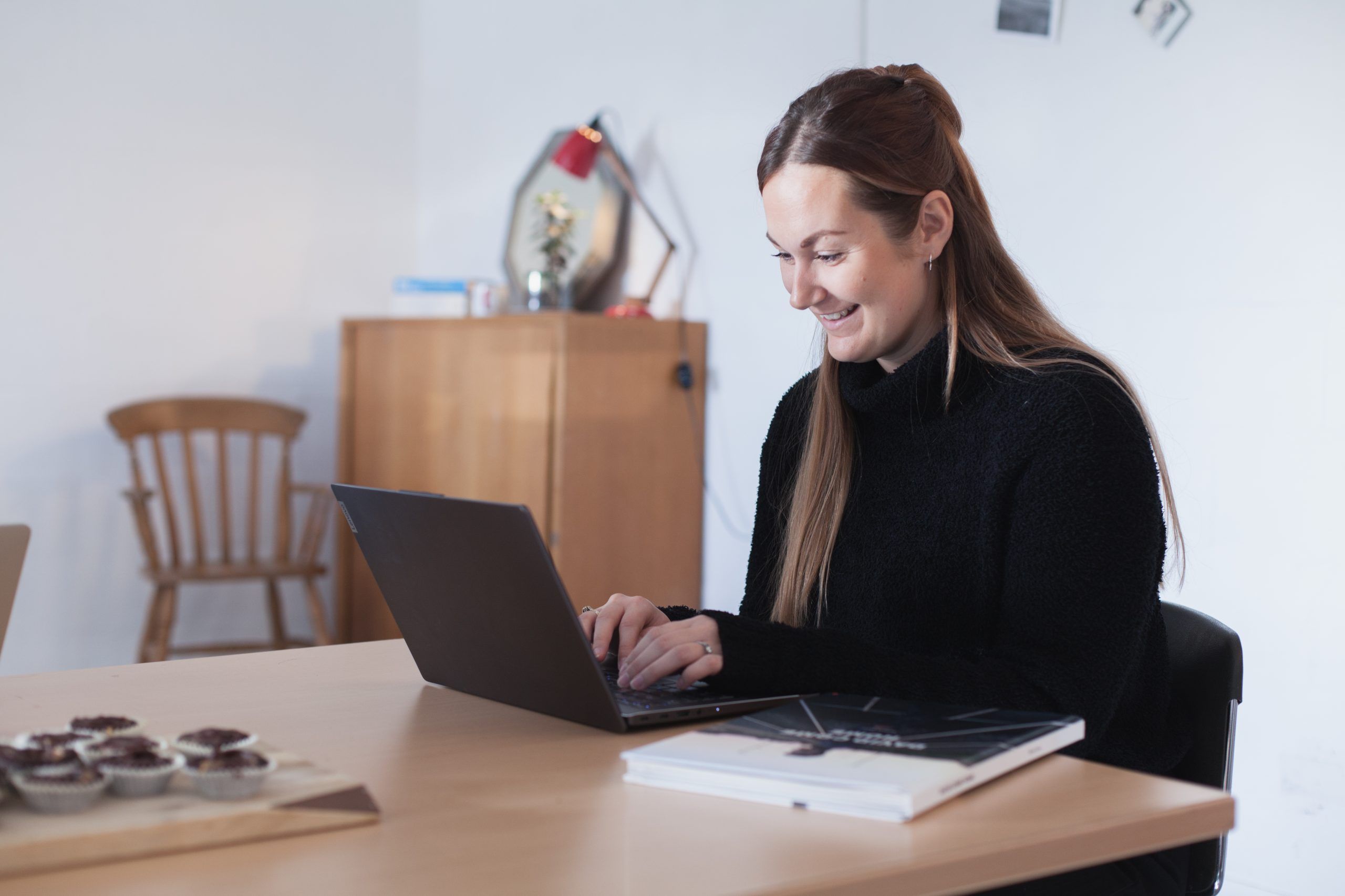 woman smiling at laptop in the office